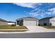 Single-story house with gray siding, two-car garage, and a well-maintained lawn at 4364 Reding Way, Lakeland, FL 33813