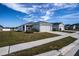 Low-slung one story house with gray siding, a two-car garage, and a grassy yard at 4364 Reding Way, Lakeland, FL 33813
