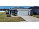 One-story home with gray siding, attached garage, and landscaped lawn at 4364 Reding Way, Lakeland, FL 33813