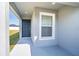 Covered front porch with dark gray door and a window with blinds at 4364 Reding Way, Lakeland, FL 33813