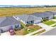 This aerial view showcases the home's tidy front yard and proximity to an open field at 566 Valentina Ln, Auburndale, FL 33823