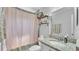 Bathroom featuring a granite-topped vanity and shower with decorative curtains at 566 Valentina Ln, Auburndale, FL 33823