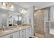 Well-lit bathroom with double vanity sinks, granite countertops, and a separate shower at 566 Valentina Ln, Auburndale, FL 33823