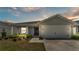 Charming single-story home with a well-manicured lawn, covered entry, and a two-car garage at 566 Valentina Ln, Auburndale, FL 33823