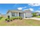Charming single-story home featuring a well-manicured lawn, a two-car garage, and a cozy front porch at 566 Valentina Ln, Auburndale, FL 33823