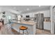 Modern kitchen and dining area with a granite-topped island, stainless steel appliances, and barstool seating at 566 Valentina Ln, Auburndale, FL 33823