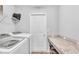 Functional laundry room featuring modern washer/dryer, folding counter, and storage shelves at 566 Valentina Ln, Auburndale, FL 33823