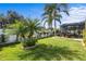 Expansive backyard with lush green grass, a white fence, and mature palm trees at 5808 Driftwood Dr, Winter Haven, FL 33884