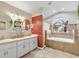 Elegant bathroom boasts double vanity, a relaxing soaking tub, and a mosaic tile accent wall at 5808 Driftwood Dr, Winter Haven, FL 33884