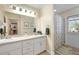 Well-lit bathroom features double sinks with updated fixtures, a large mirror, and a shower with a patterned curtain at 5808 Driftwood Dr, Winter Haven, FL 33884