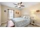 Bright bedroom with white trim, a ceiling fan, a queen bed, and a small side table at 5808 Driftwood Dr, Winter Haven, FL 33884