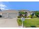 Well-manicured lawn leads up to this one-story home with a beige exterior and 3-car garage at 6683 Highlands Creek Blvd, Lakeland, FL 33813