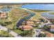 Scenic aerial view showcasing beautiful homes with tile roofs, lush landscaping, water features, and golf course views at 4101 Limerick Dr, Lake Wales, FL 33859