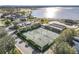 Gorgeous aerial view showcasing the community clubhouse, tennis courts, and a lake in this active community at 4101 Limerick Dr, Lake Wales, FL 33859