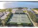 Beautiful aerial view showcasing tennis courts, shuffle board, water features, and a lake in the community at 4101 Limerick Dr, Lake Wales, FL 33859