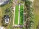 Aerial view of meticulously maintained bocce ball courts, surrounded by lush landscaping and palm trees at 4101 Limerick Dr, Lake Wales, FL 33859