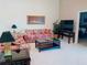 Living room with floral sofa, television, and tiled flooring at 4101 Limerick Dr, Lake Wales, FL 33859