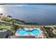 Aerial view of a sparkling community pool with lake views, surrounded by lush greenery and lounge chairs at 4101 Limerick Dr, Lake Wales, FL 33859