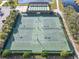Aerial view of tennis courts at this community with pristine landscaping, nearby shuffleboard, and a lake at 4101 Limerick Dr, Lake Wales, FL 33859