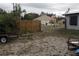 View of the backyard with metal fencing and a house with a three-car garage in the distance at 5031 Timberlane Rd, Lake Wales, FL 33898