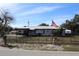 Charming single-story home with a metal roof, fenced yard, and the American flag proudly displayed at 5031 Timberlane Rd, Lake Wales, FL 33898