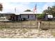 Charming single-story home with a metal roof, covered porch, fenced yard, and American flag waving out front at 5031 Timberlane Rd, Lake Wales, FL 33898