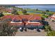 Aerial view showcasing community with red tile roofs, lake, canal and well-maintained landscaping at 802 Magnolia Pl, Winter Haven, FL 33884