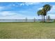 Backyard featuring lush green grass, trees, and a view of the lake beyond at 802 Magnolia Pl, Winter Haven, FL 33884
