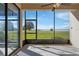 Screened lanai featuring tile flooring and a serene view of the backyard, lake and landscape at 802 Magnolia Pl, Winter Haven, FL 33884
