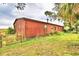 Side view of red mobile home showcasing length and yard at 8053 & 8051 Lake Lowery Rd, Haines City, FL 33844