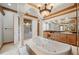 Spa-like bathroom with a large soaking tub, marble floors, and double vanities at 104 Van Fleet Ct, Auburndale, FL 33823