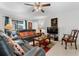 Inviting living room with a leather sofa, patterned pillows, and a ceiling fan at 1924 Amber Sweet Cir, Dundee, FL 33838