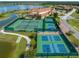 Aerial view of tennis and pickleball courts, clubhouse, and lake at 4076 Tralee Dr, Lake Wales, FL 33859