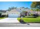 House exterior featuring a two-car garage and well-maintained landscaping at 4340 Winding Oaks Cir, Mulberry, FL 33860