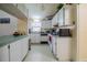 Galley kitchen with white cabinets and a view to the living room at 6102 N Fork Ct, Lakeland, FL 33809