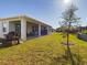 Sunny backyard with covered patio, grassy lawn and trees at 727 Annabell Ridge Rd, Minneola, FL 34715