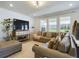 Spacious living room with a large sectional sofa, hardwood floors, and large windows at 727 Annabell Ridge Rd, Minneola, FL 34715