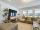 Spacious living room with a large sectional sofa, hardwood floors, and large windows at 727 Annabell Ridge Rd, Minneola, FL 34715