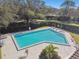 Community pool with lounge chairs and patio tables at 111 Woden Way, Winter Haven, FL 33884