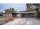 Newly renovated house with gray brick, red shutters, and a carport at 115 7Th Jpv St, Winter Haven, FL 33880