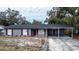 Newly renovated gray brick house with red accents, carport, and fenced yard at 115 7Th Jpv St, Winter Haven, FL 33880