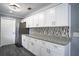 Modern kitchen with white cabinets, granite countertops, and stainless steel appliances at 115 7Th Jpv St, Winter Haven, FL 33880