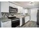 Modern kitchen with white cabinets, granite counters, and stainless steel appliances at 115 7Th Jpv St, Winter Haven, FL 33880