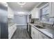 Modern kitchen with white cabinets, granite countertops, and stainless steel appliances at 115 7Th Jpv St, Winter Haven, FL 33880