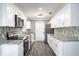 Modern kitchen with white cabinets, granite countertops, and stainless steel appliances at 115 7Th Jpv St, Winter Haven, FL 33880