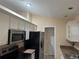 Bright kitchen boasts stainless steel appliances and white cabinets at 137 Harbor Way, Auburndale, FL 33823