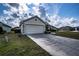 Attached garage with a long driveway and landscaping at 1548 Normandy Heights Blvd, Winter Haven, FL 33880