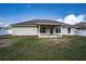 House back view showcasing a covered patio and grassy yard at 1548 Normandy Heights Blvd, Winter Haven, FL 33880