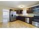 Kitchen with dark cabinets, granite counters, and stainless steel appliances at 162 N 2Nd St, Eagle Lake, FL 33839