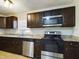 Kitchen with dark cabinets, granite counters, and stainless steel appliances at 162 N 2Nd St, Eagle Lake, FL 33839